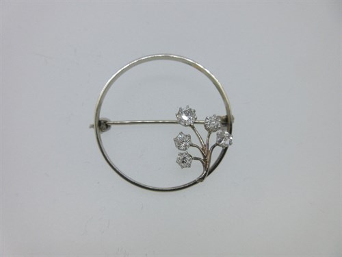 Lot 102 - A circular brooch with a diamond set flower accent