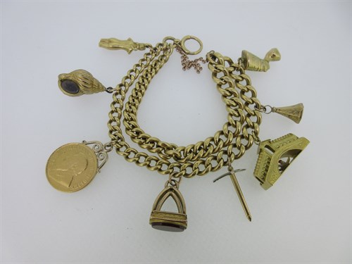 Lot 23 - An 18ct watch chain converted to a bracelet with eight charms