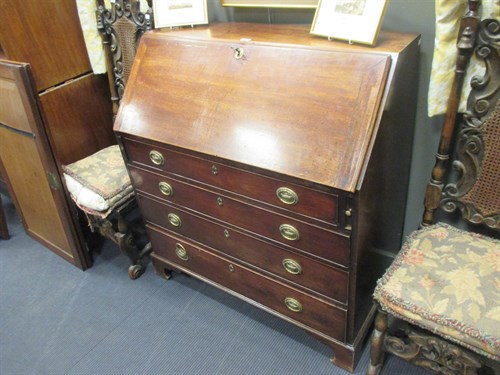 Lot 450 - A George III mahogany bureau, with oval brass...