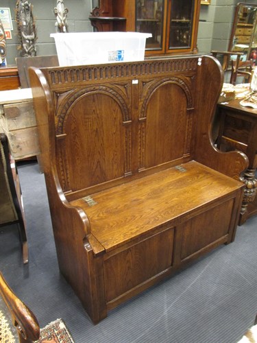 Lot 459 - An oak settle with a box base 107cm wide approx