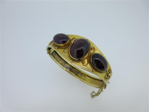 Lot 65 - A Victorian hinged bangle set with garnet carbuncles