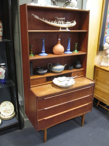 Lot 514 - A teak bookcase with three long drawers and a...