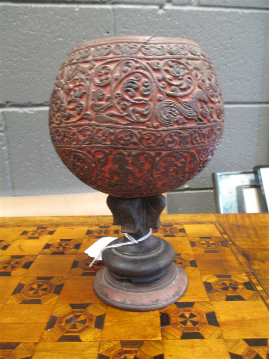 Lot 244 - A carved coconut shell on stand