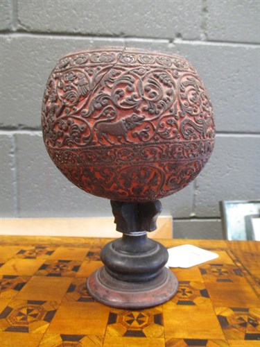 Lot 244 - A carved coconut shell on stand