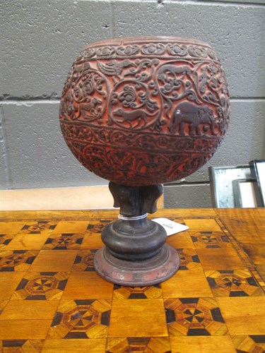 Lot 244 - A carved coconut shell on stand