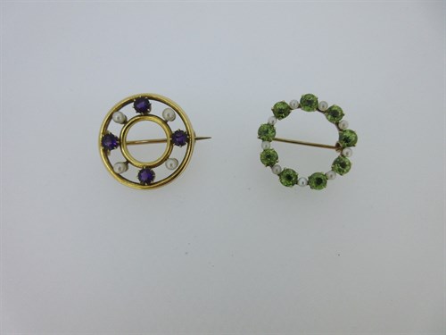 Lot 98 - A peridot and seed pearl circlet brooch together with a similar form amethyst and pearl example