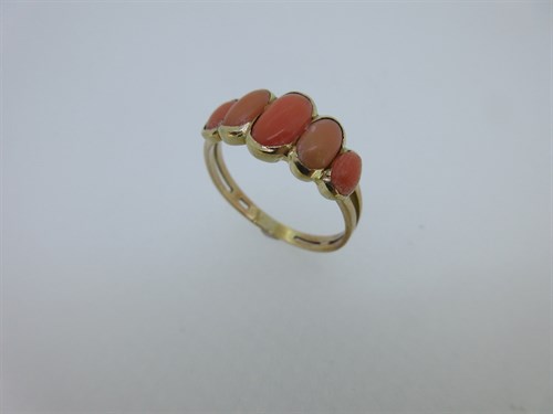 Lot 77 - A five stone coral ring