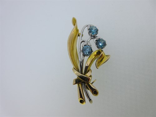 Lot 130 - A bi-colour flower spray brooch set with blue zircons