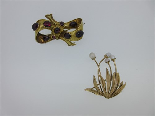 Lot 60 - A Victorian cabochon garnet bow brooch together with a mid 20th century gold and pearl brooch
