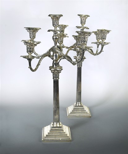 Lot 418 - A pair of George V silver four branch five light metamorphic candelabra