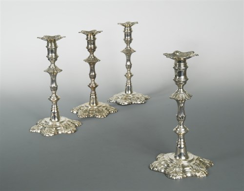 Lot 329 - A set of four George II cast silver candlesticks