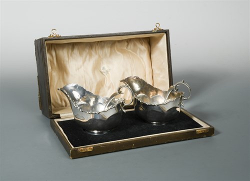 Lot 405 - A cased pair of George V silver sauce boats with sauce ladles en suite