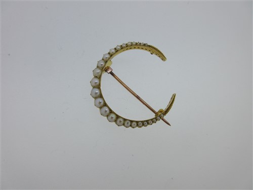 Lot 244 - A closed crescent brooch set with seed pearls