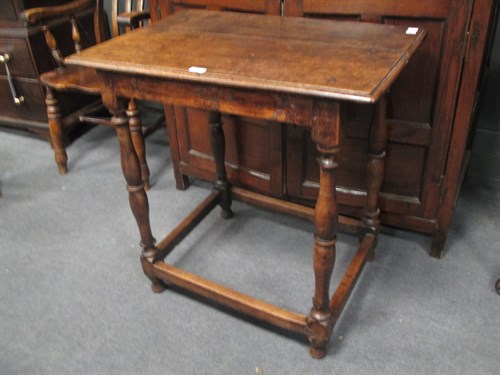 Lot 672 - An 18th century oak table on turned baluster...