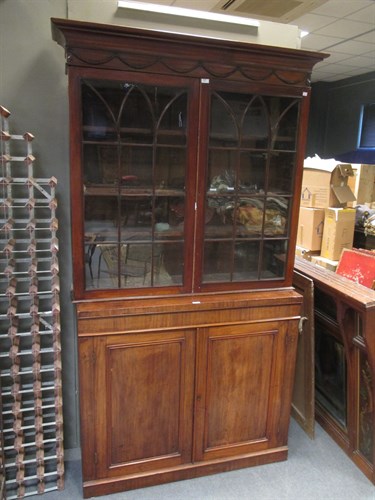Lot 691 - A mahogany glazed bookcase with a later base,...