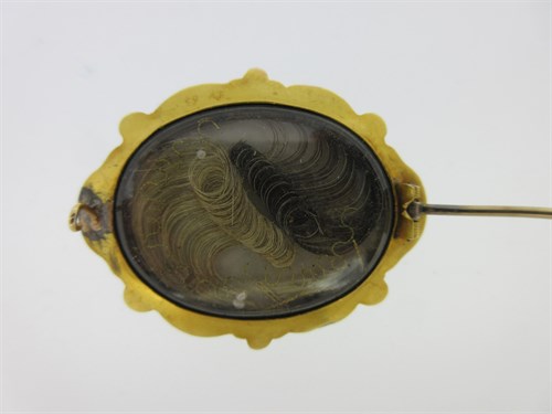 Lot 307 - An emerald, seed pearl and filigree brooch circa 1840 with hairwork compartment