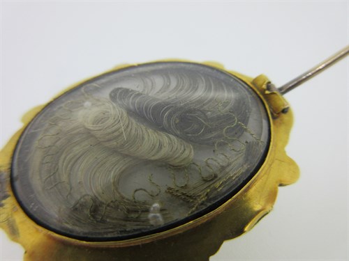 Lot 307 - An emerald, seed pearl and filigree brooch circa 1840 with hairwork compartment