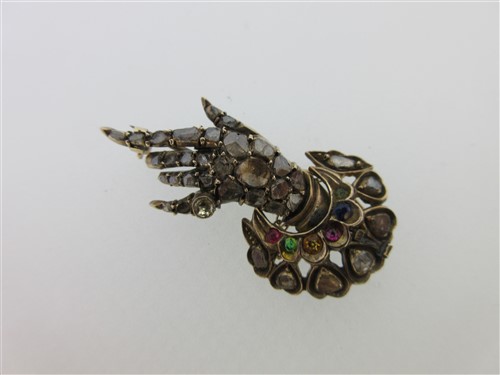 Lot 101 - A diamond and gem set hand and cuff brooch
