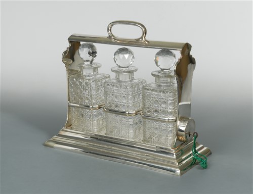 Lot 496 - A silver plated and cut glass three bottle tantalus