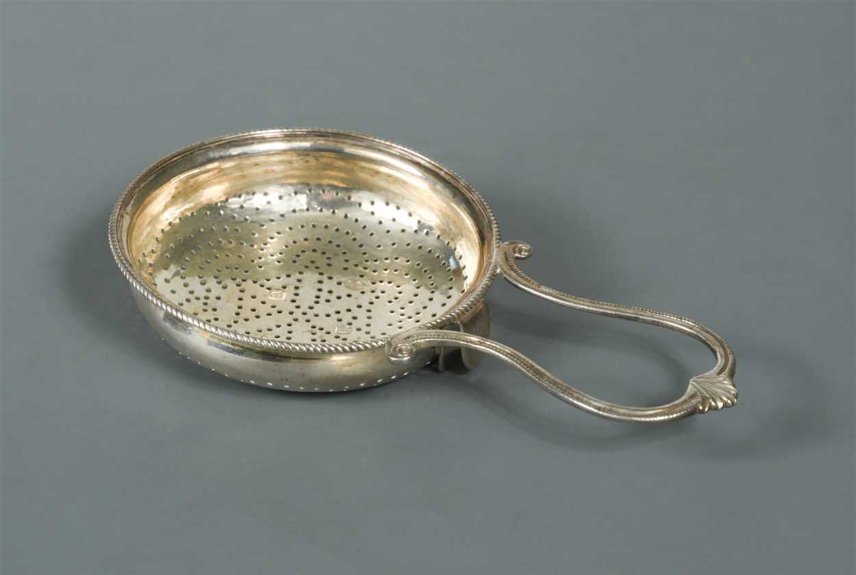 Lot 572 - A George III silver lemon strainer