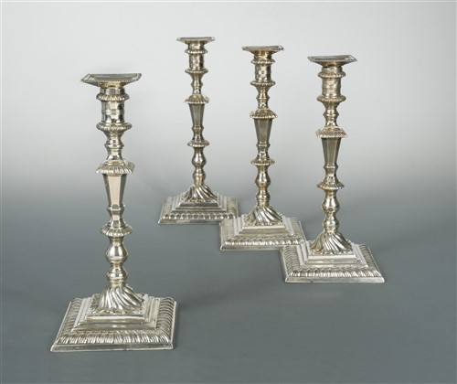 Lot 562 - A matched set of four George II / III cast silver candlesticks