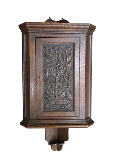 Lot 237 - An Arts & Crafts oak hanging corner cupboard
