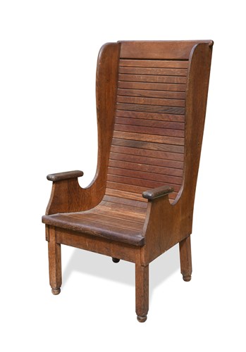 Lot 240 - An early 20th century oak wing back arm chair