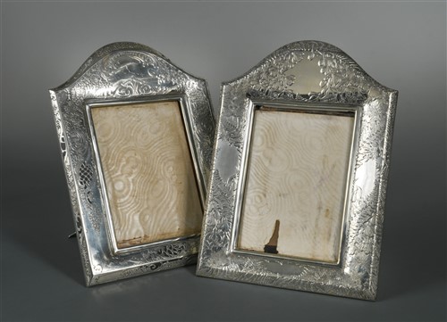Lot 516 - A pair of early 20th century American metalwares easel back photograph frames by Tiffany & Co