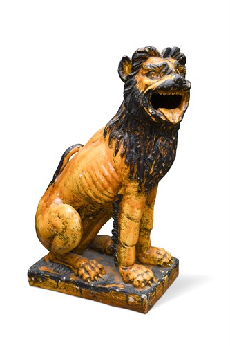Lot 85 - A glazed terracotta figure of a seated lion