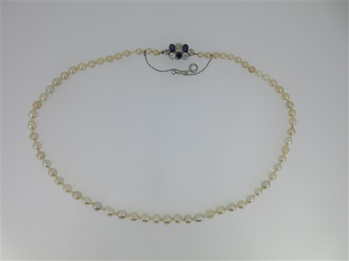 Lot 194 - A single row of graduated pearls with a sapphire and diamond clasp
