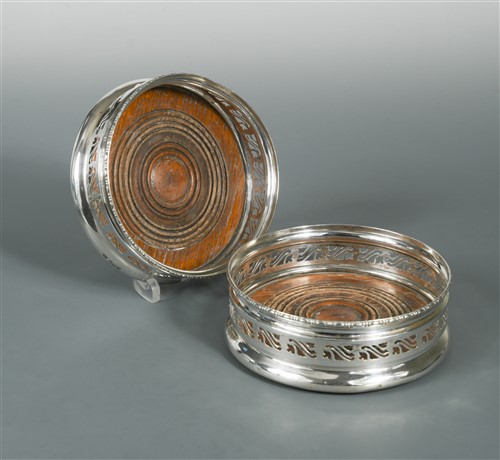 Lot 677 - A pair of George VI silver bottle coasters
