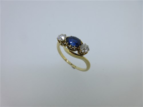Lot 293 - A sapphire and diamond three stone ring with crossover band