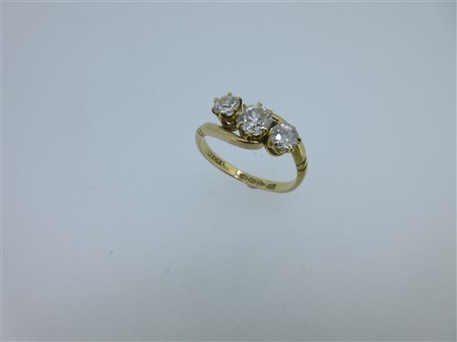 Lot 176 - An antique 18ct gold and diamond three stone cross over ring