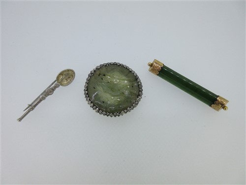 Lot 108 - A circular jadeite clip, a nephrite jade brooch and a replica anointing spoon brooch