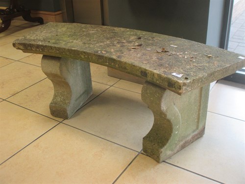 Lot 672 - A curved composite stone garden bench approx...