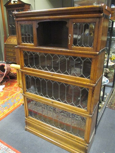 Lot 546 - An oak leaded glazed four section stacking...