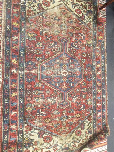 Lot 694 - A red ground rug with central lozenge and...