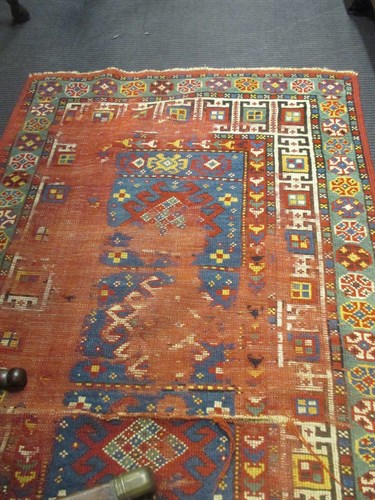 Lot 701 - A worn red ground rug 162 x 95 (A/F)