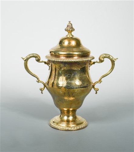 Lot 589 - A George III silver gilt two handled trophy cup and cover