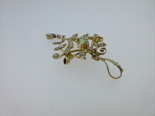 Lot 214 - An Edwardian peridot and seed pearl pendant / brooch