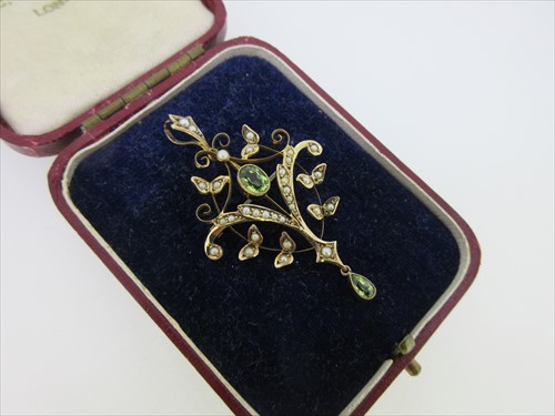 Lot 214 - An Edwardian peridot and seed pearl pendant / brooch
