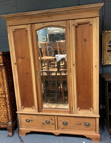 Lot 655 - A stripped pine wardrobe, with central arched...