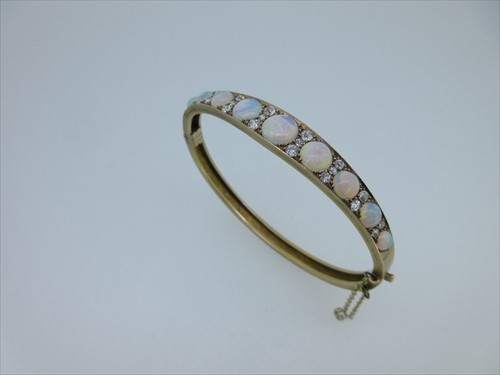 Lot 81 - An opal and diamond hinged bangle