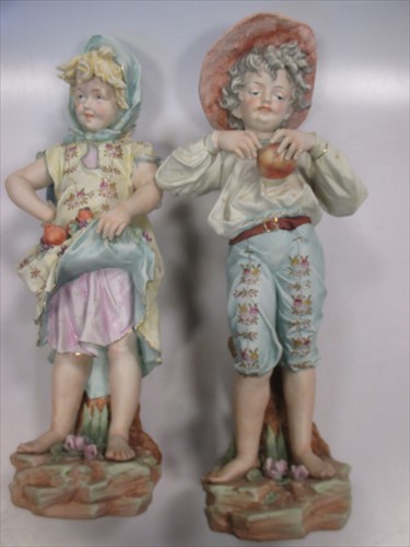 Lot 266 - A pair of late 19th Century bisque procelain figures of a boy and girl.