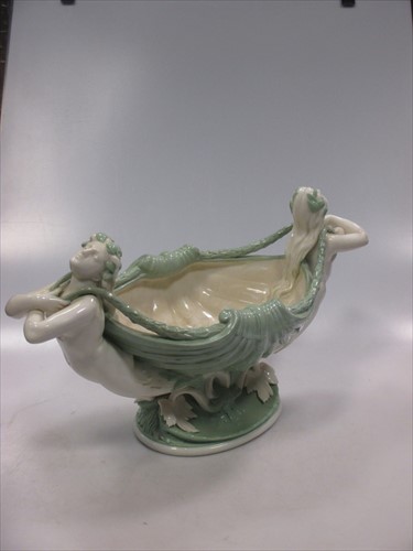 Lot 11 - A late 19th Century Minton jadinere, green body of shell form supported by mermaids.