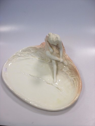 Lot 19 - A late 19th century continental pottery  tray of a lady washing er feet in a pond.