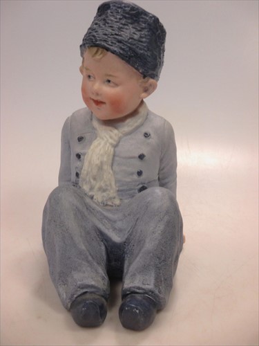 Lot 2 - A Heubach piano doll of a young boy.
