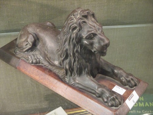 Lot 6 - In the manner of Landseer, a bronze lion on wooden plinth