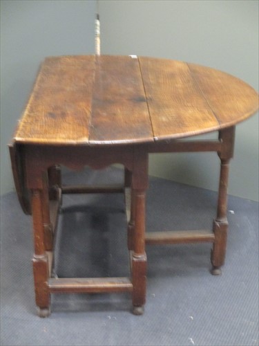 Lot 613 - An 18th century oak gateleg table on turned...