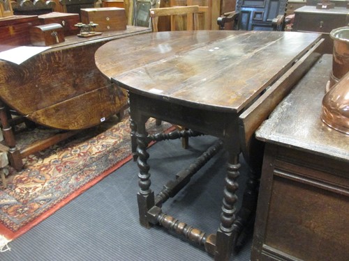 Lot 374 - A large oak gateleg table on barley twist legs...
